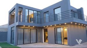 a house with glass doors and a balcony at Violetta Villa Chalet in Madaba