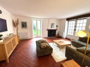 a living room with a couch and a table at Villa des Malons - Maison à 100m de la plage in Saint-Aubin-sur-Mer