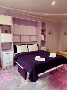 a bedroom with a purple bed with towels on it at Apartments Provence in Chernivtsi
