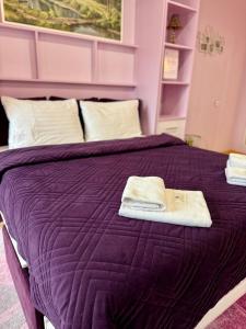 a purple bed with two towels on top of it at Apartments Provence in Chernivtsi