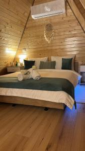 a bedroom with a large bed in a wooden wall at A Frame Bâlea Chalet in Cârțișoara