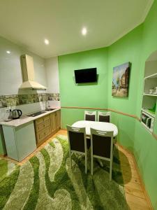 a kitchen with a table and a green wall at Apartments Provence in Chernivtsi