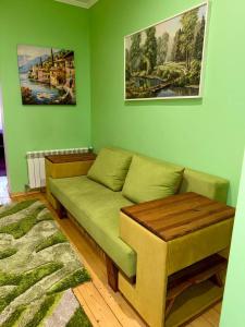 a living room with a couch and a green wall at Apartments Provence in Chernivtsi