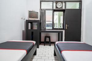 Postel nebo postele na pokoji v ubytování Collection O Tasikmalaya Near Stadium Wiradadaha Formerly Hotel Abadi