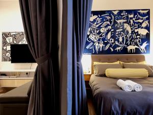 een slaapkamer met een bed met een blauw-witte muur bij The Shore Artsy Studio Kota Kinabalu in Kota Kinabalu +27 foto's