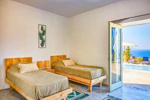 a bedroom with two beds and a view of the ocean at Villa Thea by Villa Plus in Skinária +12 photos