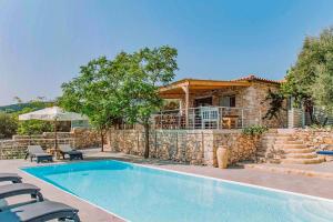 a house with a swimming pool in front of a building at Villa Dassos by Villa Plus in Skinária