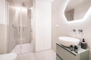a white bathroom with a sink and a shower at Easylife - Duomo Deluxe Apartments #5-11 in Milan +152 photos