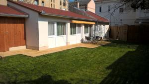 a backyard with a patio with a grass yard at Gereben Apartman Pécs in Pécs