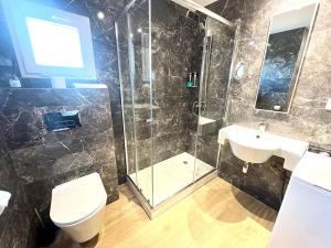 a bathroom with a shower and a toilet and a sink at Apartamento Velázquez Aeropuerto B in Málaga +7 photos