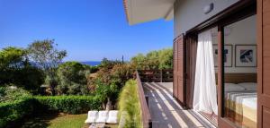 a balcony of a house with a view of a garden at Cyan Villa in Anavyssos
