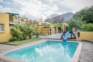 a swimming pool with a slide in front of a building at Country Village in Graaff-Reinet