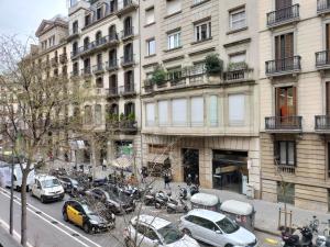 Una calle de la ciudad con coches aparcados delante de un edificio. en Anais Apartments by gaiarooms, en Barcelona