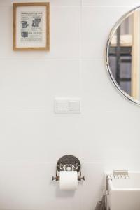 a bathroom with a toilet paper dispenser and a mirror at Apartment by the cathedral II in Lublin