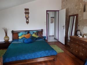 a bedroom with a bed with a blue comforter at LOGÉVEIL - Maison d'hôtes ''Charme et Bien-être'' - proche forêt et golf in Baugé-en-Anjou +7 photos