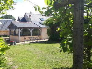 a pavilion with a table and chairs in a yard at LOGÉVEIL - Maison d'hôtes ''Charme et Bien-être'' - proche forêt et golf in Baugé-en-Anjou