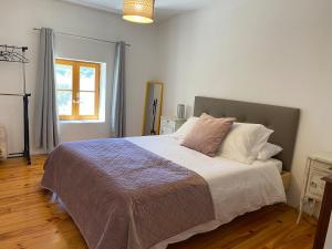 una camera da letto con un letto grande e una finestra di Les Deux Marronniers Bataille a Saint-Georges-de-Longuepierre