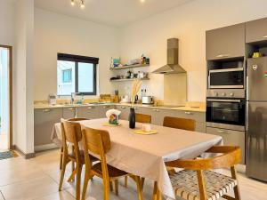 a kitchen with a table and chairs in a kitchen at Blue Zebra - T4 Oasis - Rivière, Mer et Piscine in Rivière Noire
