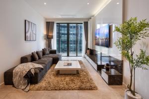 a living room with a couch and a table at Lè Métropole Saigon in Ho Chi Minh City