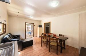 a living room with a table and a couch at Camping Village Tuscia Tirrenica in Tarquinia