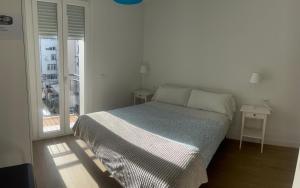 a white bedroom with a bed and a window at Apartaments Plaza Príncipe Viana in Pamplona