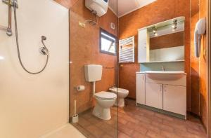 a bathroom with a toilet and a sink and a shower at Camping Village Tuscia Tirrenica in Tarquinia