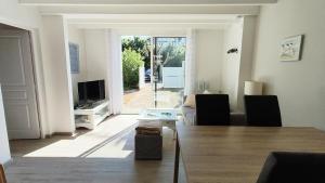 アンデルノ・レ・バンにあるVilla Les Goëlands 6 personnes à 50 m de la plageのテーブルとテレビのあるリビングルーム
