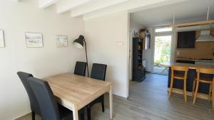 アンデルノ・レ・バンにあるVilla Les Goëlands 6 personnes à 50 m de la plageのダイニングルーム、キッチン(木製テーブル、椅子付)