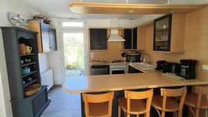 アンデルノ・レ・バンにあるVilla Les Goëlands 6 personnes à 50 m de la plageのキッチン(木製のカウンター、椅子付)