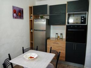a small kitchen with a table and a refrigerator at Appartement meublé in Constantine