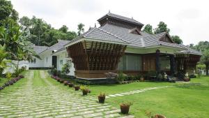 una casa con un patio con macetas delante de ella en Kudajadri Heritage Pool Homestay Kothamangalam, en Kotamangalam 10 fotos más