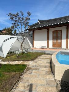 a house with a pool and an umbrella in the yard at Yeomok Stay in Gyeongju