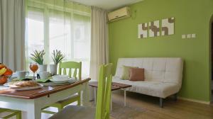 a living room with a table and a white couch at Апартамент Деа - Apartment Dea in Byala