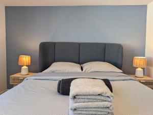 ein Schlafzimmer mit einem Bett mit zwei Lampen und Handtüchern darauf in der Unterkunft Arcachon Centre - Le 33 Tartas - Parking Inclus in Arcachon