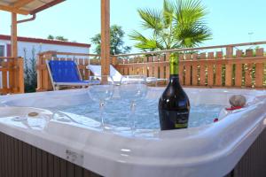 a bottle of wine and two wine glasses in a hot tub at Camping Village Tuscia Tirrenica in Tarquinia