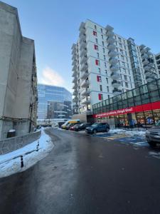 a city street with cars parked next to tall buildings at RULU Studio Plaza Mall in Bucharest