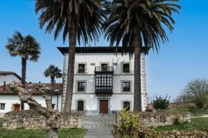 a house with palm trees in front of it at Apartamento Tejasturias in Noriega