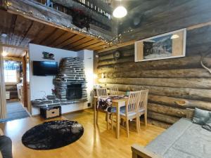 comedor con paredes de madera, mesa y sillas en Huipuntupa A6, en Syöte