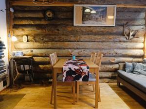 una mesa con un edredón delante de una pared de madera en Huipuntupa A6, en Syöte
