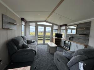 a living room with two couches and a tv at Swift Bordeaux Sea View 10 in Ardentinny