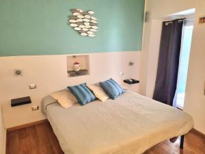 a bedroom with a bed with blue pillows on it at Vibes 5terre in Riomaggiore