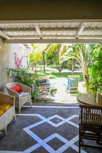 a patio with chairs and a table and a table and chairs at Villa Corail - Premier repas offert sur place in Cap Malheureux