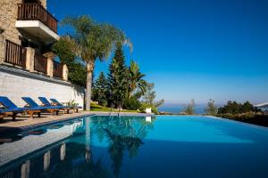 a swimming pool with lounge chairs next to a building at Demetriou Paradisos Hills Hotel in Lyso