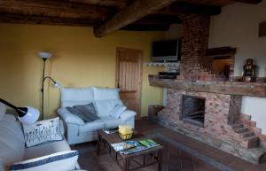 a living room with a couch and a fireplace at Observatorio de Aves Mas de Bunyol in Valderrobres