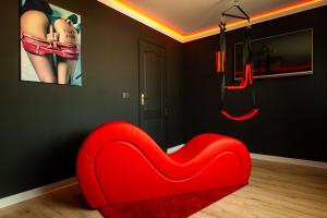 a red heart shaped chair in a living room at Desire Loft in Alba Iulia