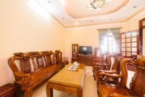 a living room with wooden furniture and a tv at Đoàn An điều dưỡng 198 in Khu Chi Lăng