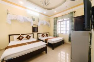 a bedroom with two beds and a tv in it at Đoàn An điều dưỡng 198 in Khu Chi Lăng +11 photos
