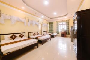 a hotel room with two beds and a desk at Đoàn An điều dưỡng 198 in Khu Chi Lăng