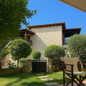 een huis met een stoel voor een tuin bij Sea and Stone Villa in Afitos