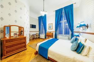 a bedroom with a large bed and blue curtains at Cotton House Budapest in Budapest